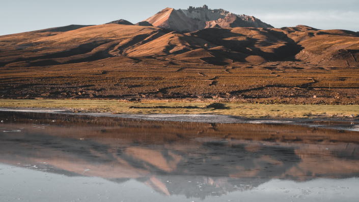salt flat bolivia volcano with snow sunset